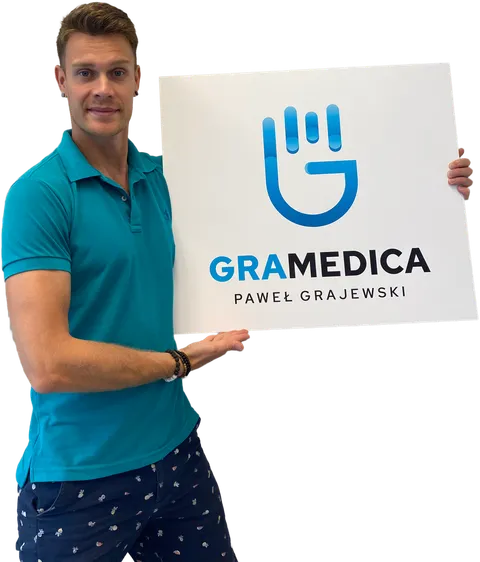 Paweł Grajewski holding the GraMedica clinic sign